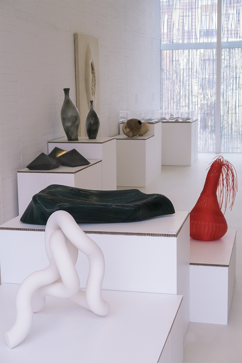 Peanas de cartón mostrando piezas de cerámica en evento sostenible