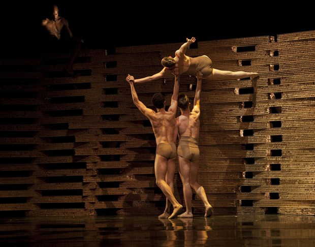 Bailarines interactuando con escenografía de cartón en Triangle of the Squinches