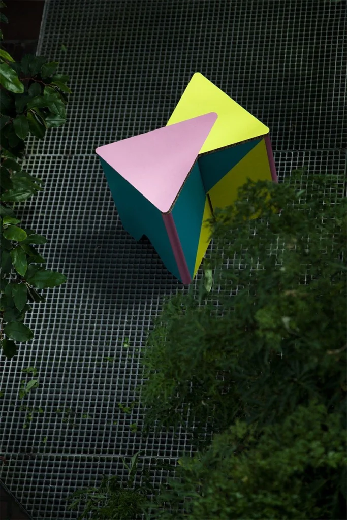 Taburete de cartón impreso INFIX en plano cenital con ramas alrededor