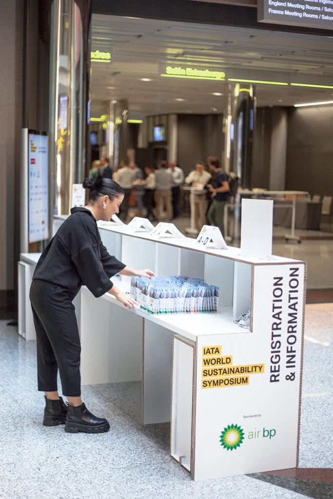 Lateral del mostrador de cartón con la impresión gráfica corporativa del evento