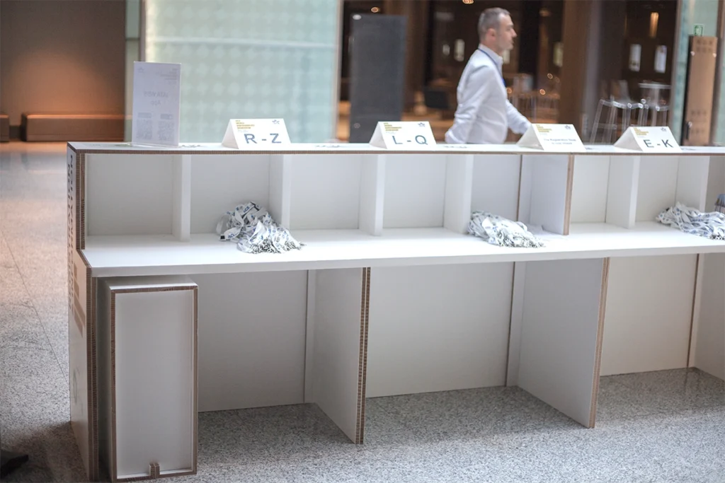 Vista del interior del mostrador de cartón mostrando el espacio para ordenador y acreditaciones