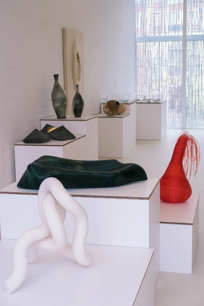 Peanas de cartón mostrando piezas de cerámica en evento sostenible