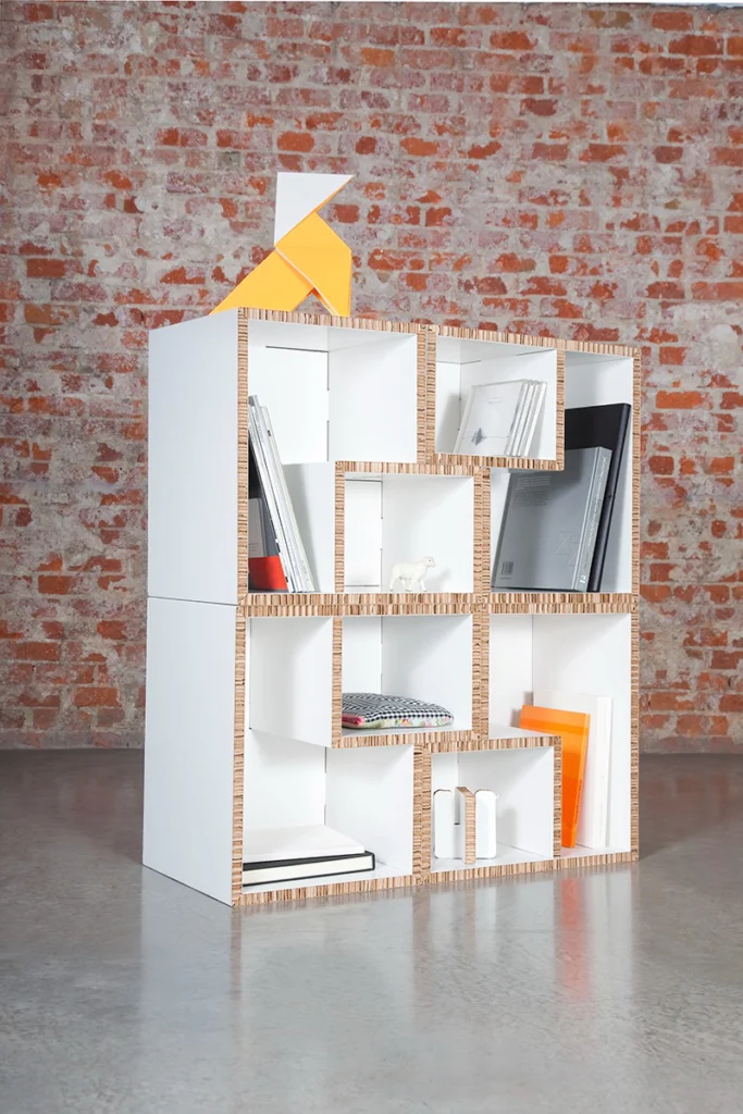 Estantería modular de cartón con módulos reconfigurados en sala industrial del Matadero Madrid